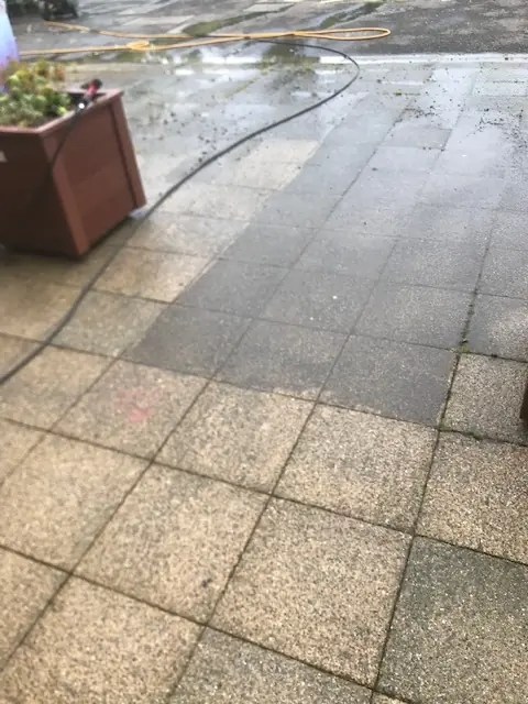 Paving slabs part-way through cleaning, showing the clean and dirty sides